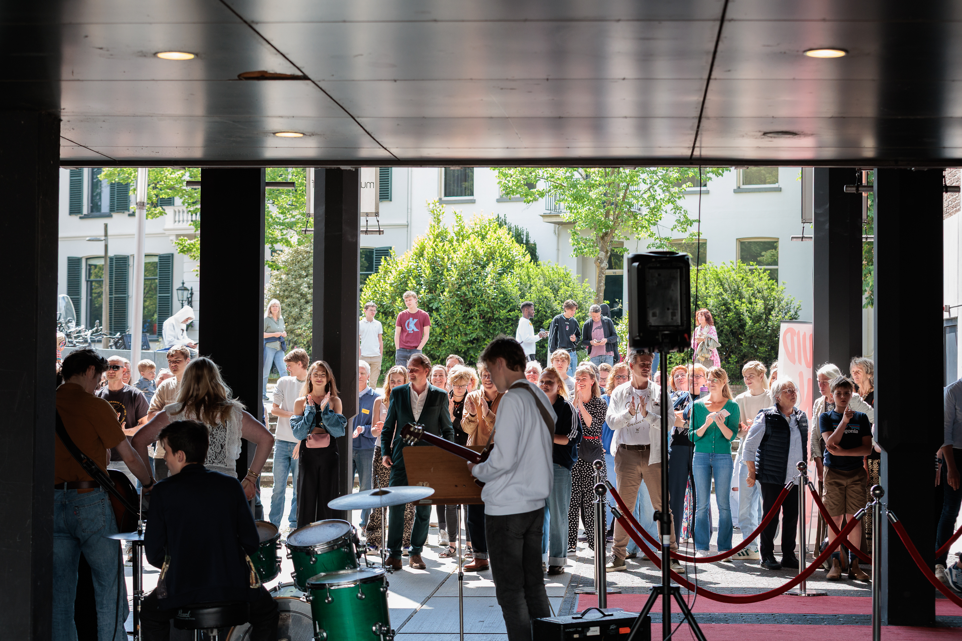 De band van achteren gezien met veel publiek ervoor