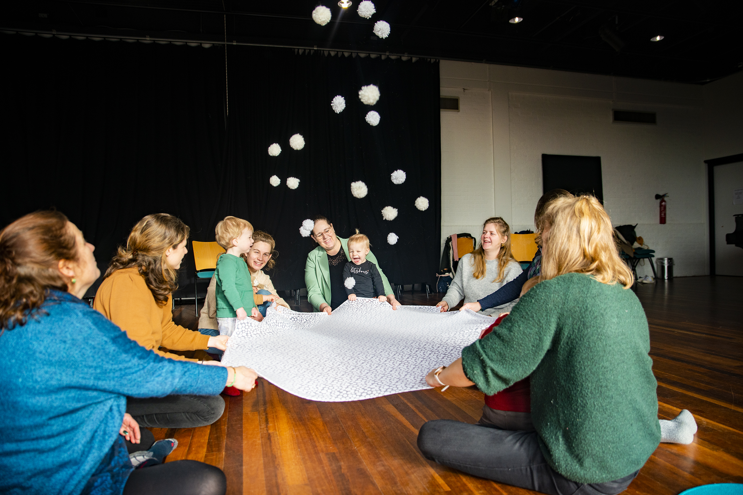 Veel plezier voor verzorger en kind in het omhooggooien van zachte witte balletjes